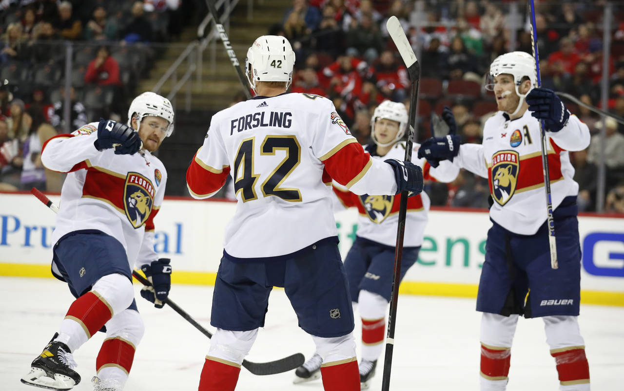 Florida Panthers defenseman Gustav Forsling (42) celebrates with teammates after scoring a goal aga...