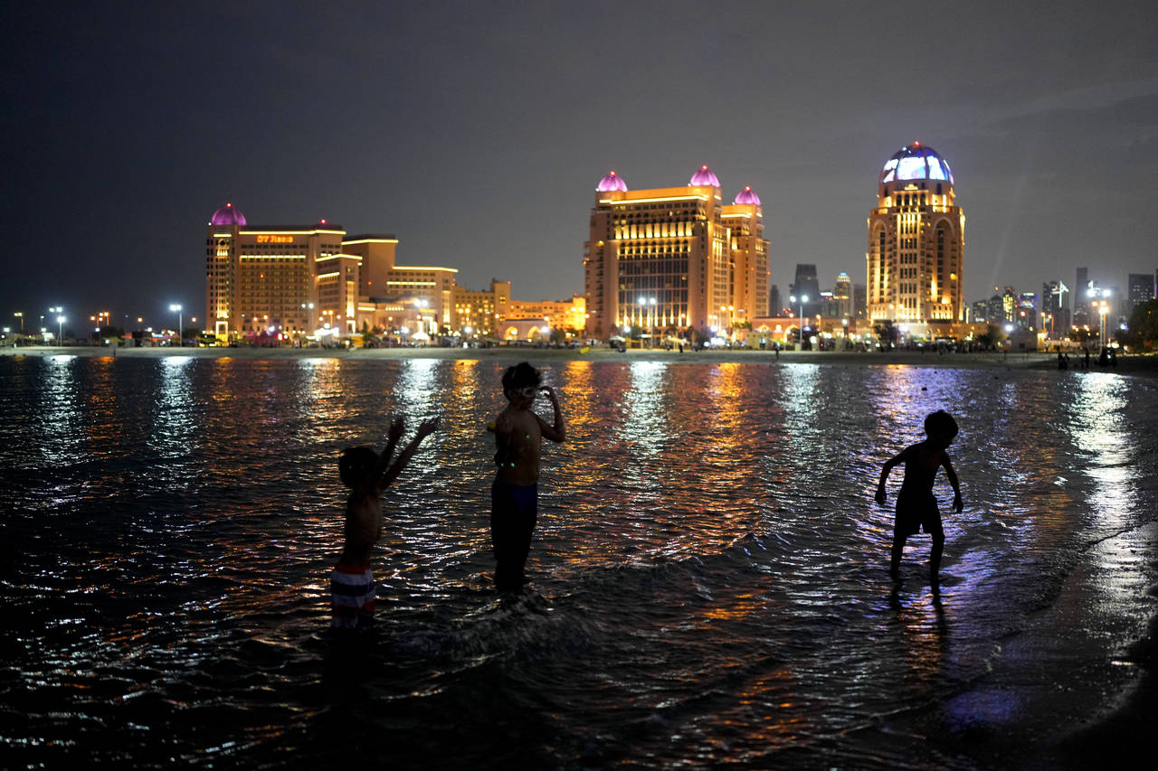 Children play on the water in Katara beach in Doha, Qatar, Thursday, Dec. 8, 2022. (AP Photo/Natach...