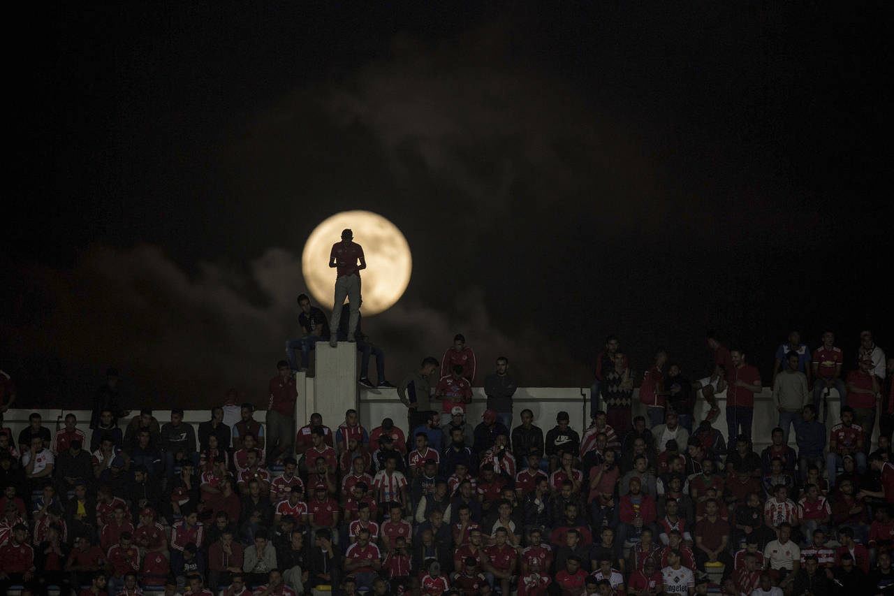A full moon rises over supporters of Wydad Athletic Club during the second leg of the CAF Champions...