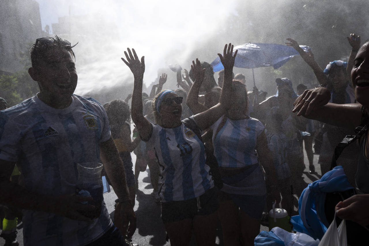 Soccer fans waiting for a homecoming parade for the players who won the World Cup title, are cooled...