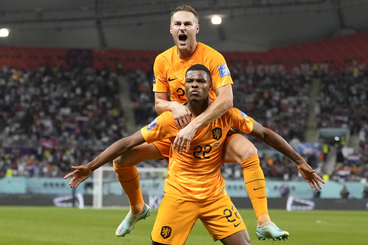 Denzel Dumfries of the Netherlands, bottom, is congratulated after scoring his side's 3rd goal duri...