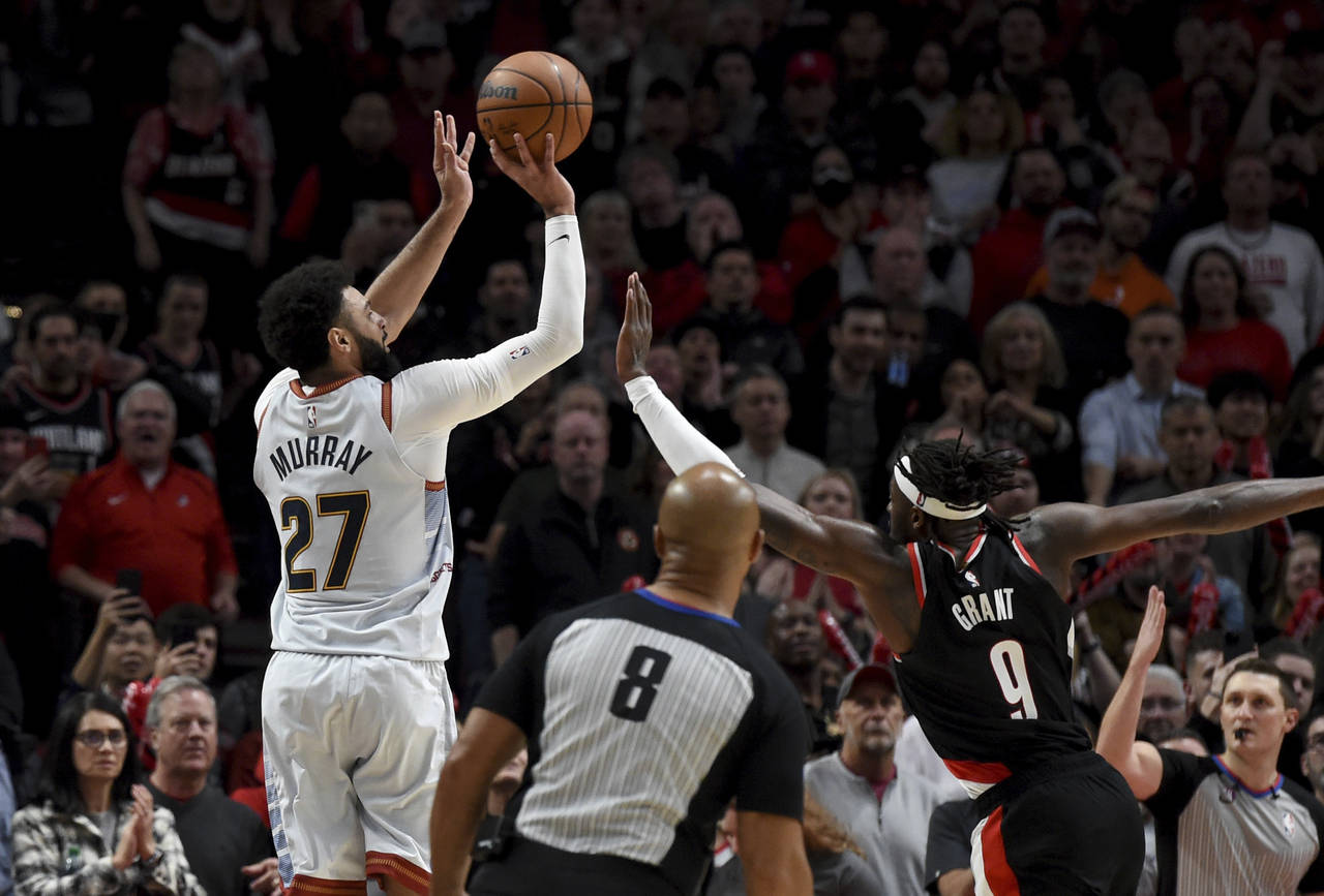 Denver Nuggets guard Jamal Murray, left, hits a 3-pointer with less than a second left in the NBA b...
