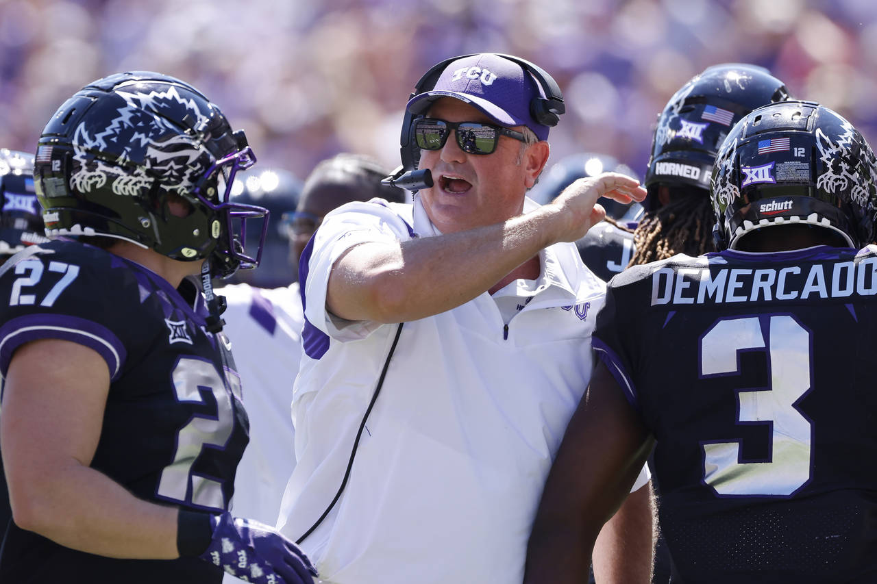 FILE - TCU head coach Sonny Dykes celebrates with his players after TCU scored a touchdown against ...
