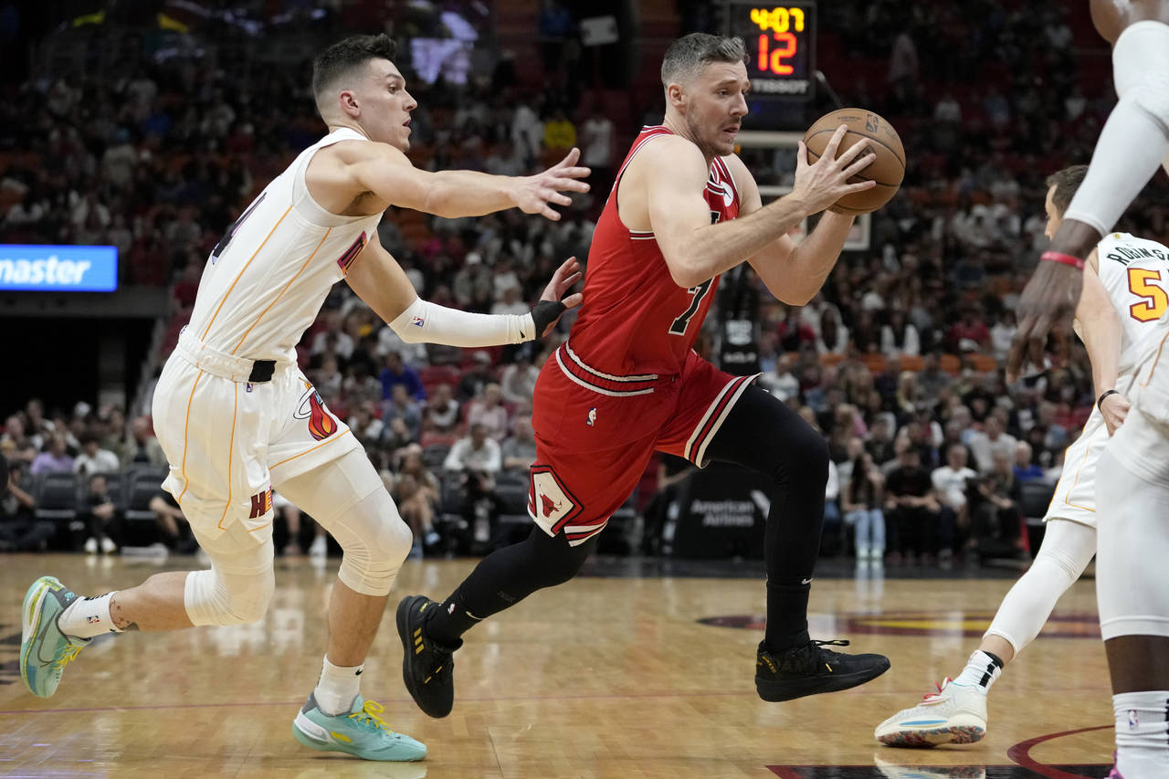 Chicago Bulls guard Goran Dragic, right, drives to the basket as Miami Heat guard Tyler Herro defen...