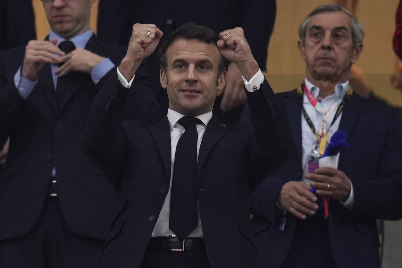FILE - French president Emmanuel Macron gestures during the World Cup semifinal soccer match betwee...