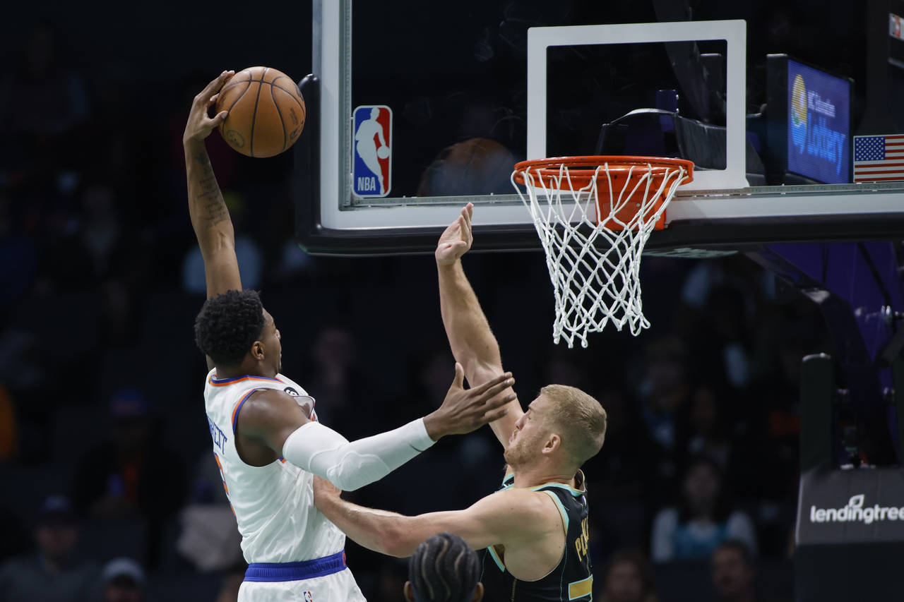 New York Knicks guard RJ Barrett, left, drives for a dunk against Charlotte Hornets center Mason Pl...