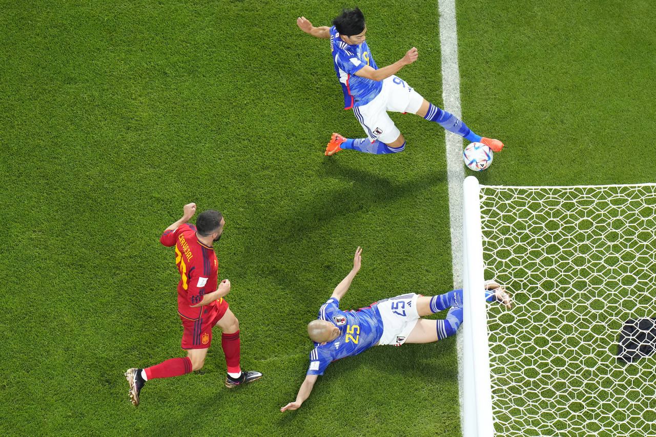 Japan's Kaoru Mitoma appears to have the ball over the line before crossing it for a goal during th...