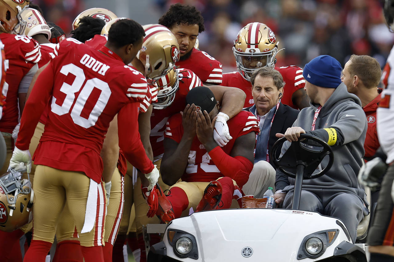 San Francisco 49ers wide receiver Deebo Samuel, middle, reacts as he is carted off the field during...