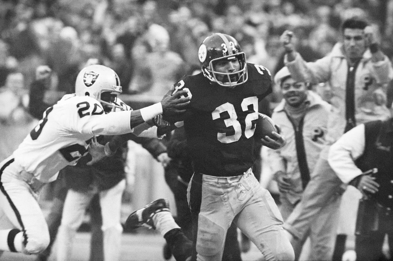 FILE - Pittsburgh Steelers' Franco Harris (32) eludes a tackle by Oakland Raiders' Jimmy Warren as ...