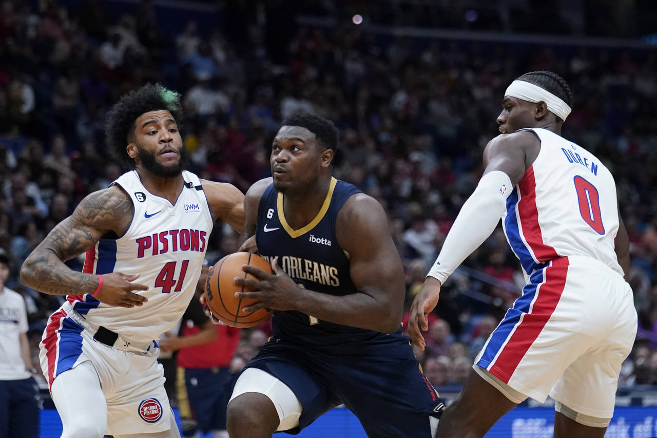 New Orleans Pelicans forward Zion Williamson (1) drives to the basket between Detroit Pistons forwa...