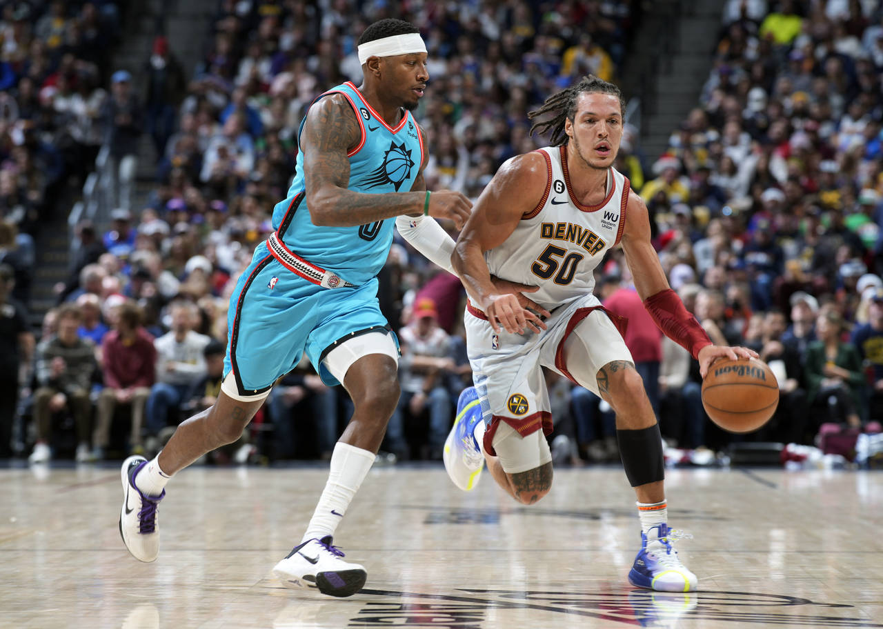 Denver Nuggets forward Aaron Gordon, right, drives past Phoenix Suns forward Torrey Craig in the fi...