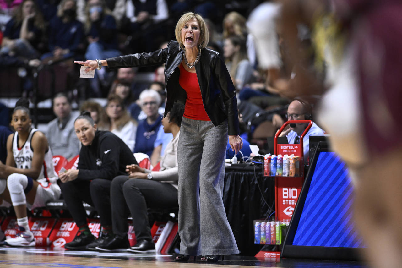 Associate head coach Chris Dailey calls out to her team during the first half of an NCAA college ba...