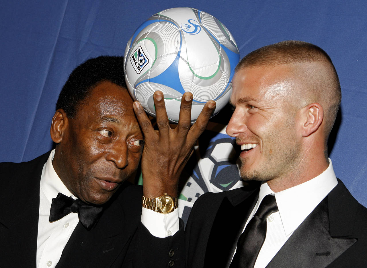 FILE - Brazilian soccer great Pele, and English soccer star David Beckham pose for photos during a ...