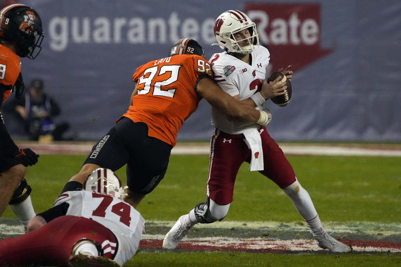Oklahoma State defensive end Nathan Latu (92) sacks Wisconsin quarterback Chase Wolf during the sec...