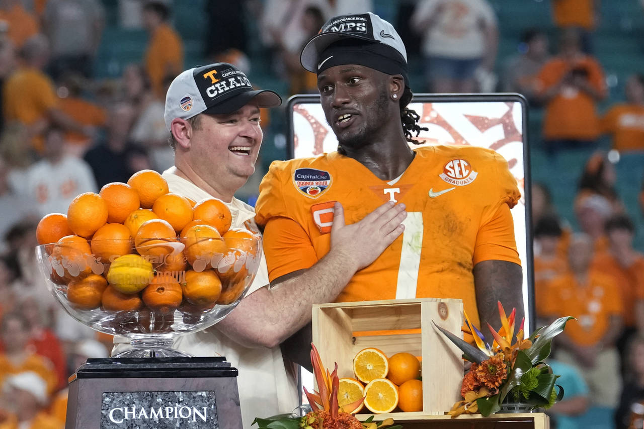 Tennessee coach Josh Heupel, left, and quarterback Joe Milton III (7) stand behind the trophy after...