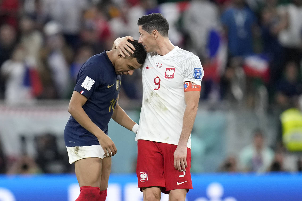 France's Kylian Mbappe, left, and Poland's Robert Lewandowski, right, speak after the World Cup rou...