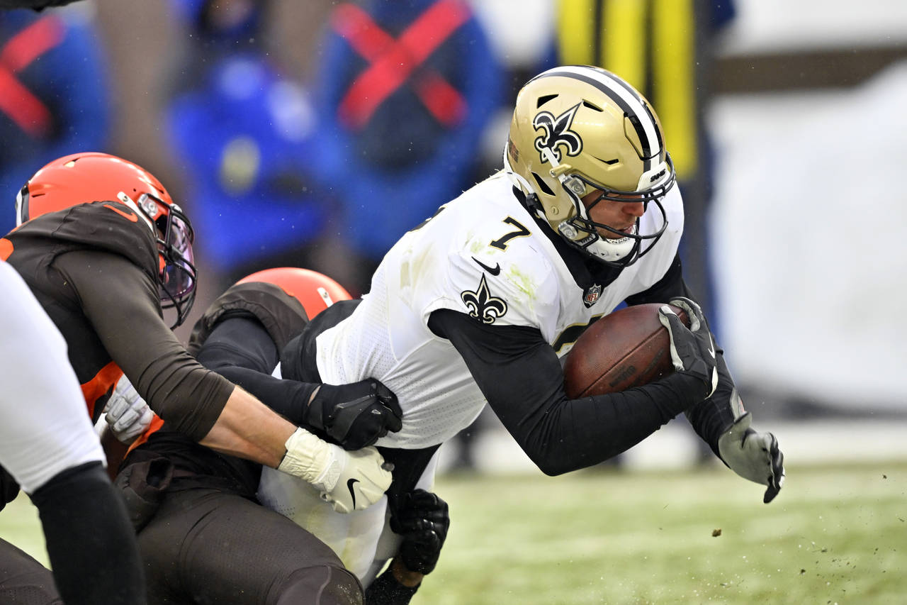 New Orleans Saints tight end Taysom Hill (7) carries Cleveland Browns defenders into the end zone f...