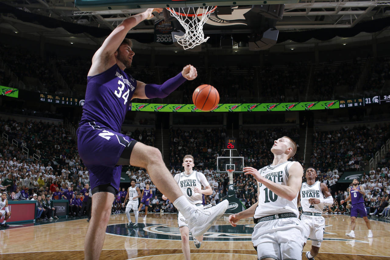 Northwestern's Matthew Nicholson, left, dunks against Michigan State's Joey Hauser (10) during the ...