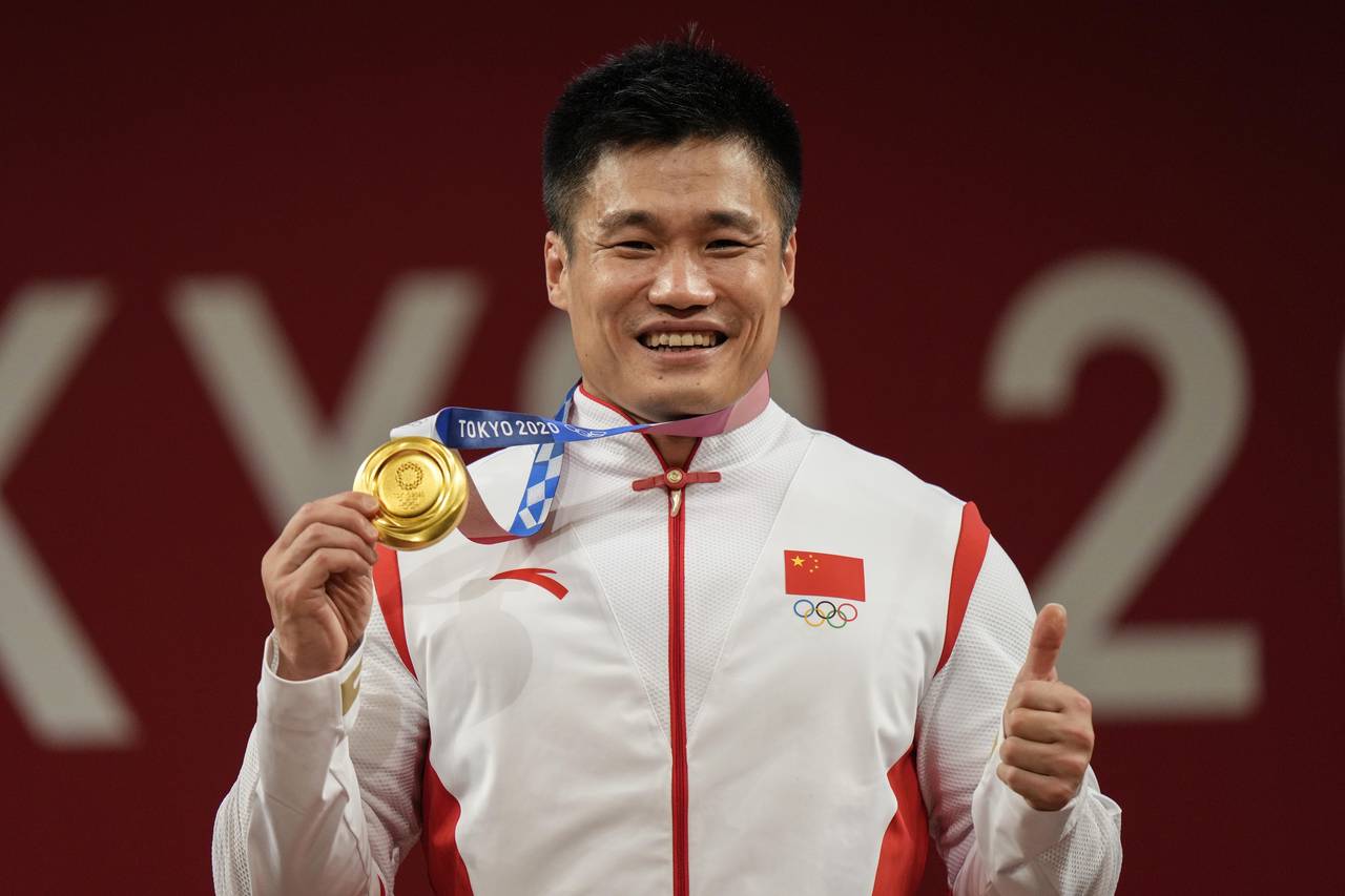 FILE - Lyu Xiaojun of China celebrates on the podium after winning the gold medal in the men's 81kg...