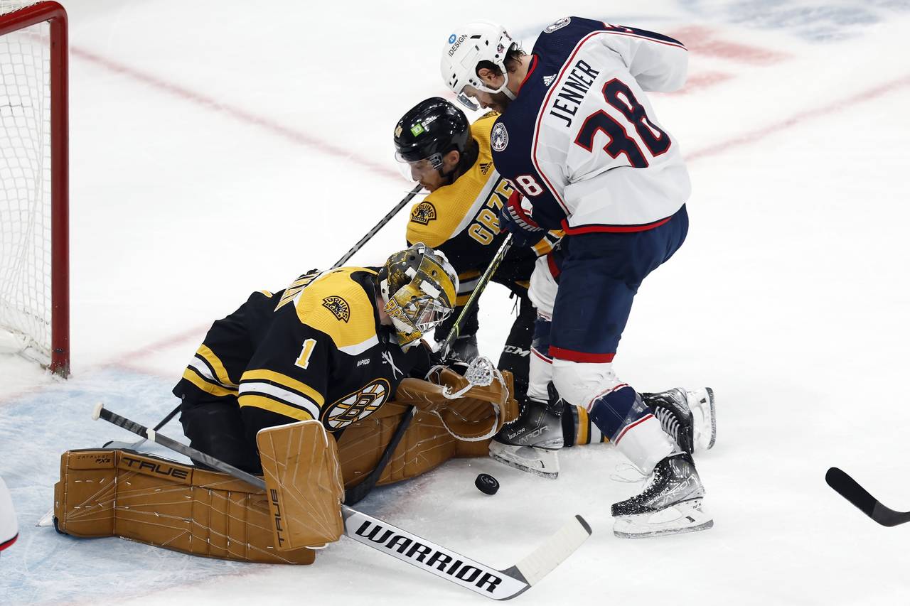 Columbus Blue Jackets' Boone Jenner (38) tries to get a shot past Boston Bruins' Jeremy Swayman (1)...