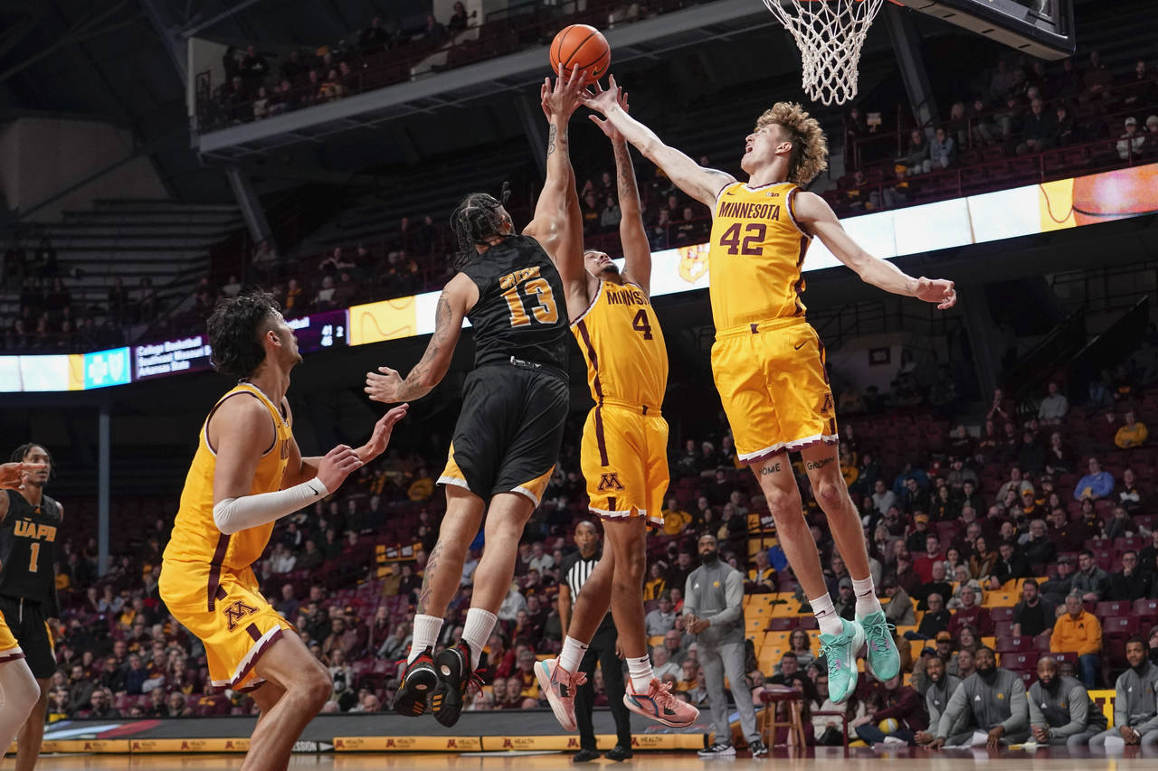 Arkansas-Pine Bluff forward Chris Greene (13), Minnesota guard Braeden Carrington (4) and center Tr...