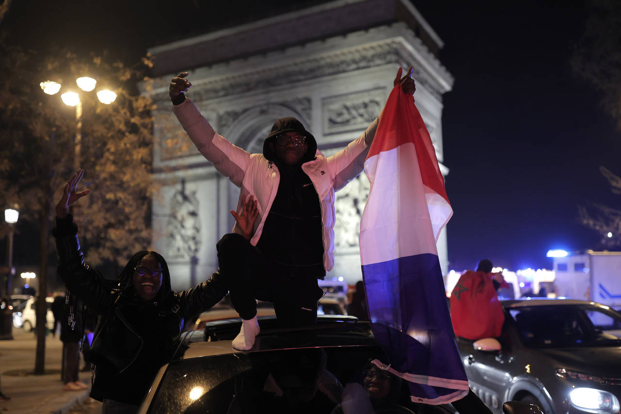France supporters celebrate France's victory with French flags at the Arc de Triomphe after the Wor...