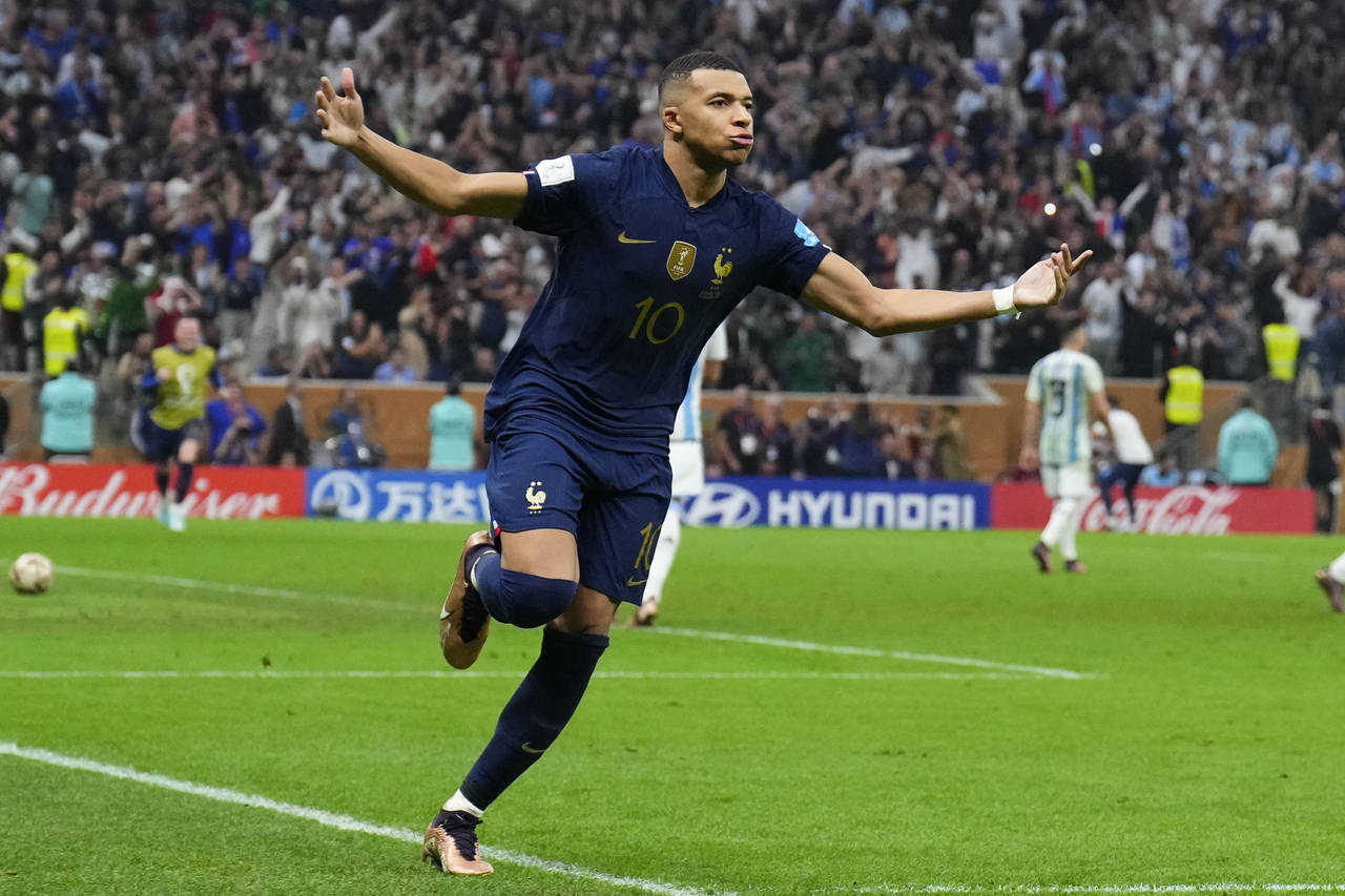 France's Kylian Mbappe celebrates scoring from the penalty spot his side's third goal during the Wo...