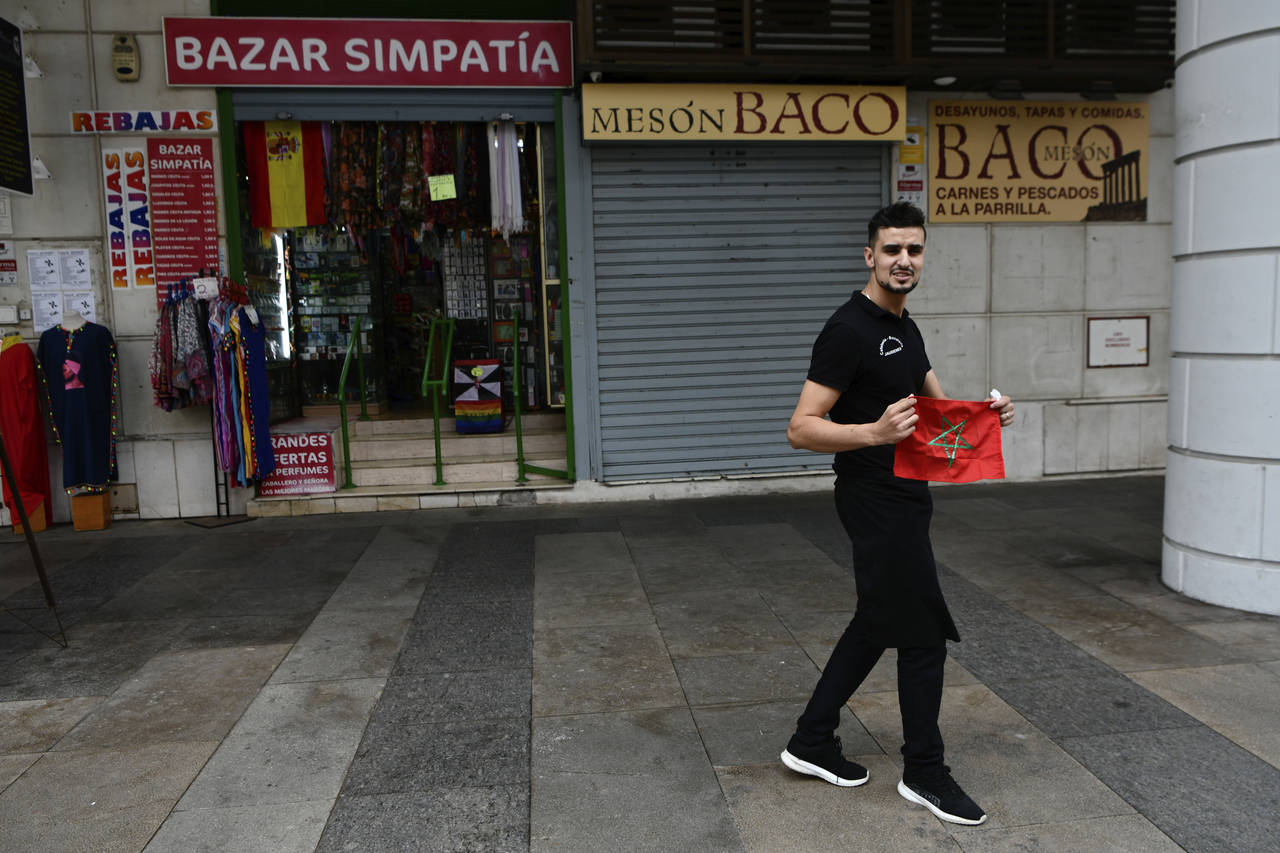 A man poses with a Moroccan flag in Spain's north African enclave of Ceuta, Monday, Dec. 5, 2022. T...
