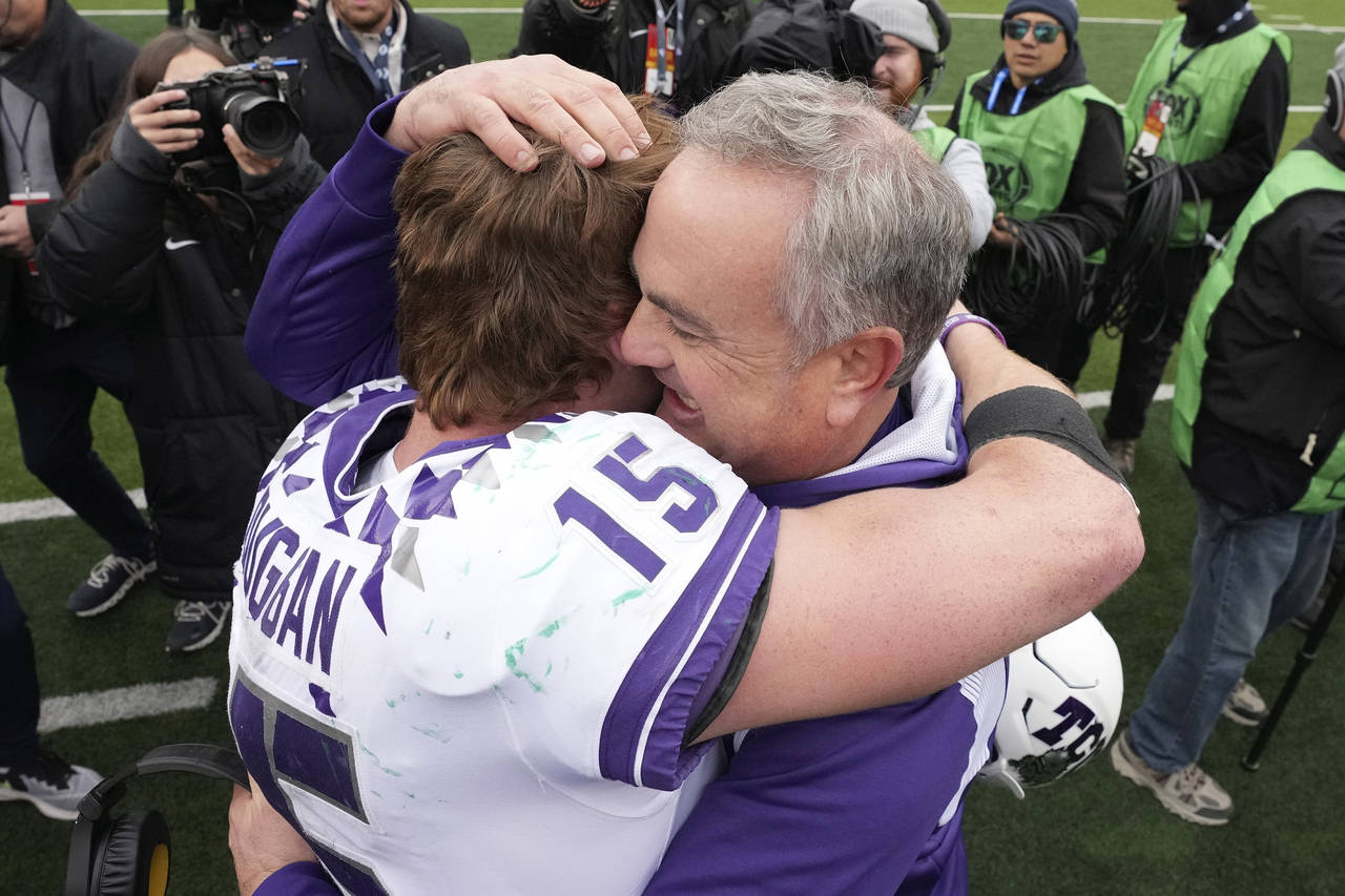 FILE - TCU head coach Sonny Dykes, right, hugs quarterback Max Duggan (15) after an NCAA college fo...
