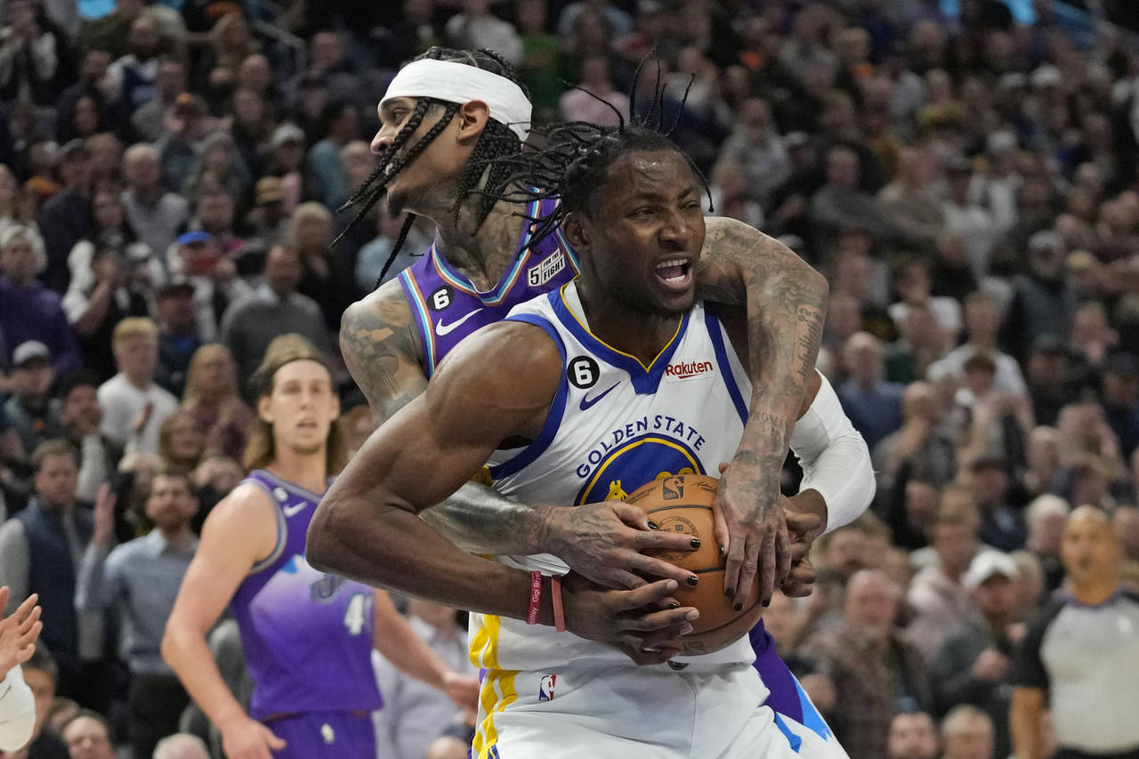 Utah Jazz guard Jordan Clarkson, rear, fouls Golden State Warriors forward Jonathan Kuminga during ...