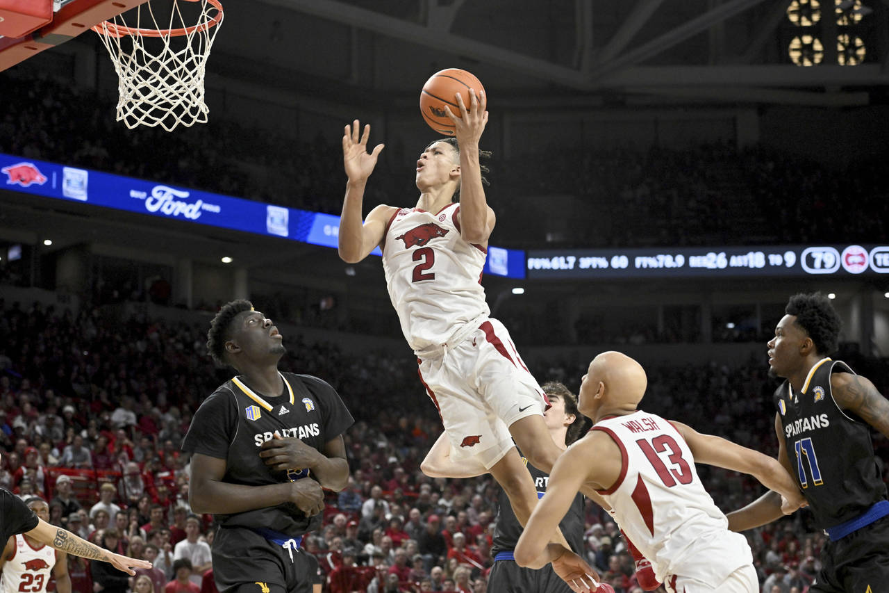 Arkansas forward Trevon Brazile (2) drives past San Jose State center Ibrahima Diallo (left) to sco...