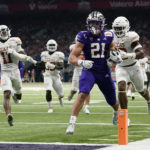 
              Washington running back Wayne Taulapapa (21) scores a touchdown against Texas on a 42-yard run during the first half of the Alamo Bowl NCAA college football game in San Antonio, Thursday, Dec. 29, 2022. (AP Photo/Eric Gay)
            