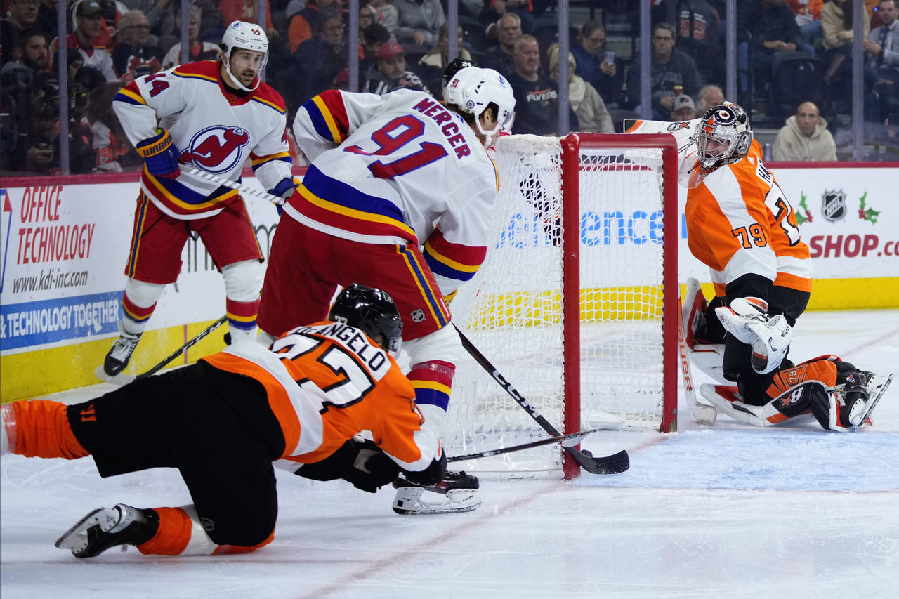 New Jersey Devils' Dawson Mercer (91) scores a goal against Philadelphia Flyers' Tony DeAngelo (77)...