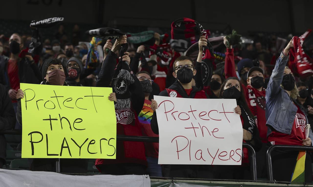 FILE - Portland Thorns fans hold signs during the first half of the team's National Women's Soccer ...