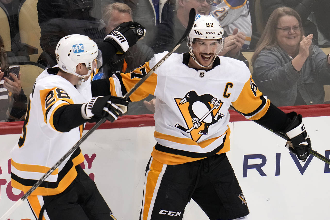 Pittsburgh Penguins' Sidney Crosby (87) celebrates his goal against the Buffalo Sabres with Marcus ...