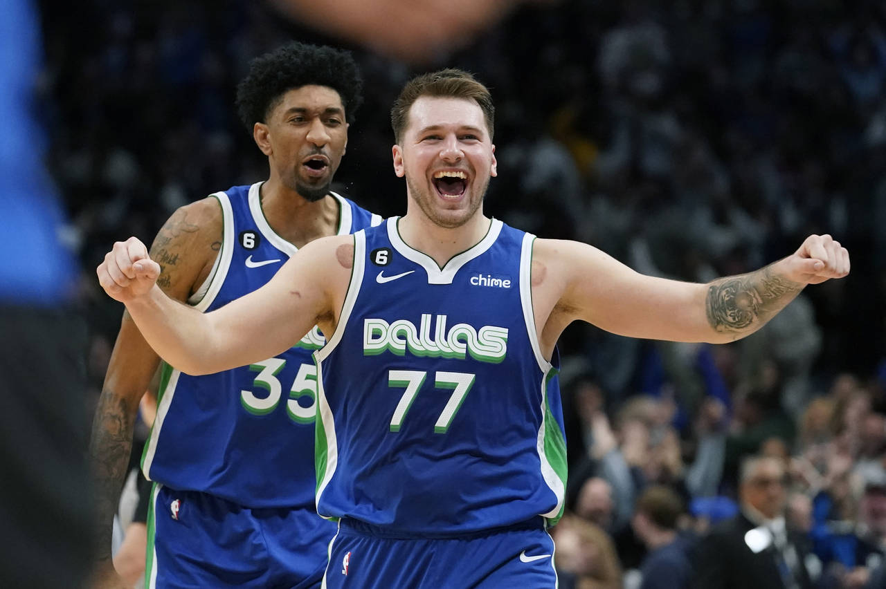 Dallas Mavericks guard Luka Doncic (77) celebrates scoring the game tying basket in front of teamma...