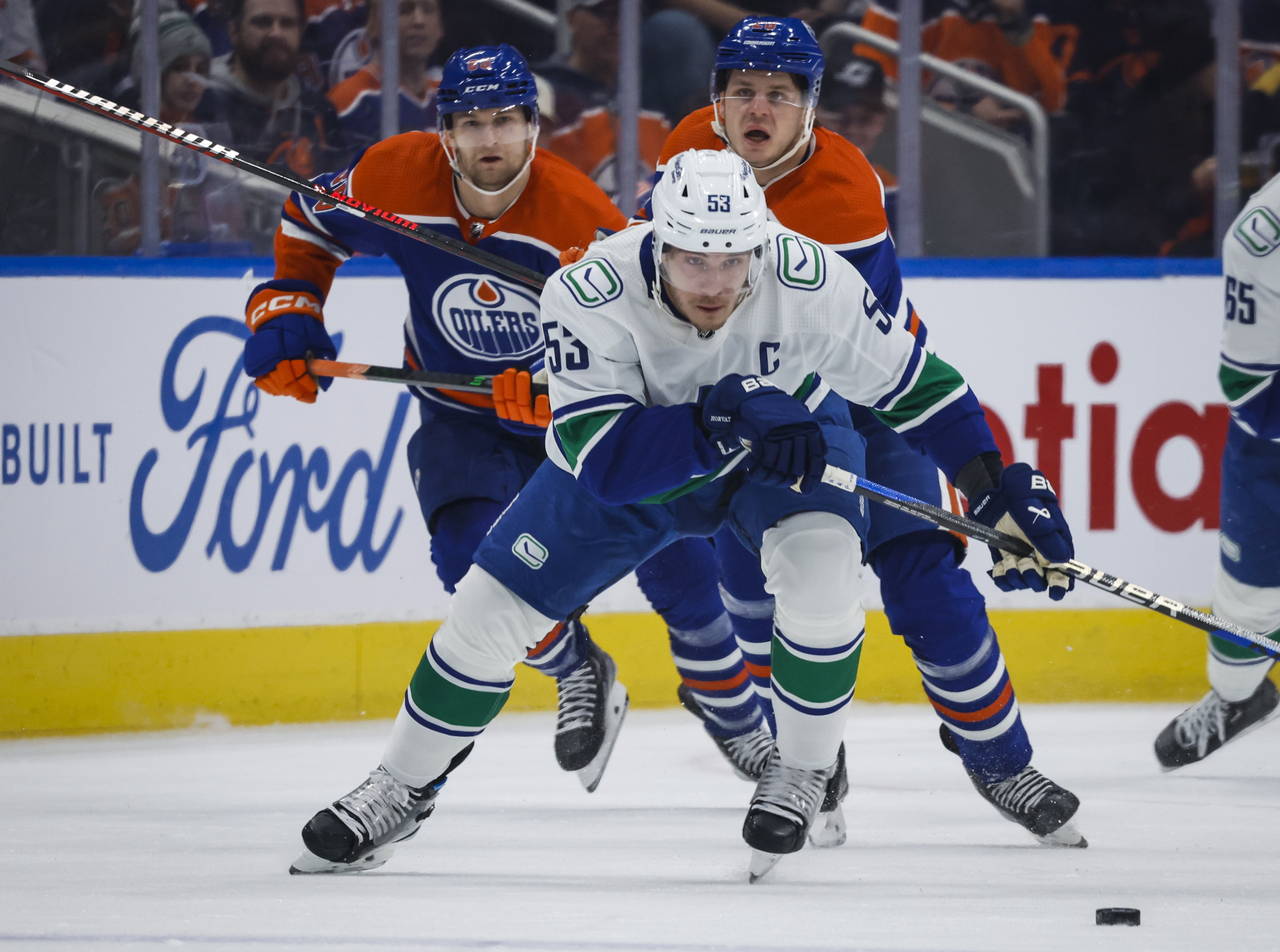 Vancouver Canucks forward Bo Horvat, center, is chased by Edmonton Oilers defenseman Markus Niemela...
