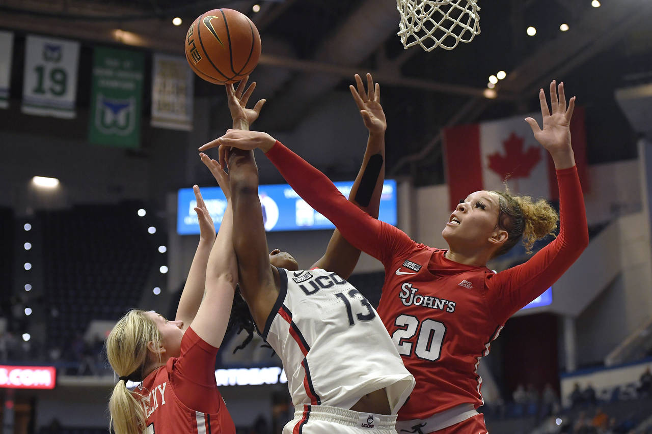 FILE - St. John's Rayven Peeples (20) fouls Connecticut's Christyn Williams (13) as St. John's Sara...