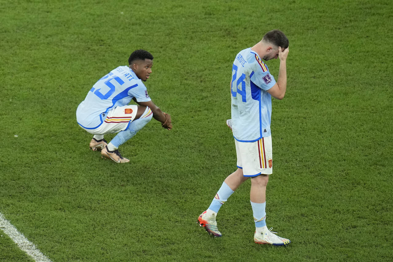 Spain's Ansu Fati, left, and Spain's Aymeric Laporte stand in dejection at the end of the World Cup...