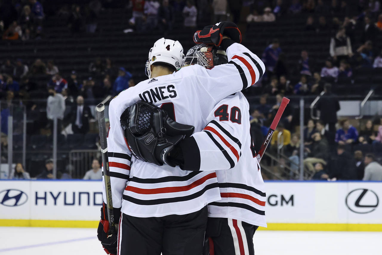 Chicago Blackhawks defenseman Seth Jones (4) and goaltender Arvid Soderblom (40) embrace after defe...