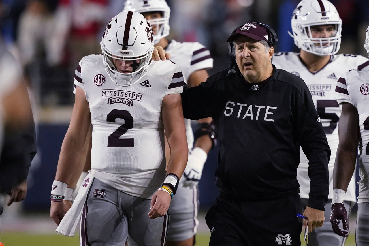 Mississippi State coach Mike Leach confers with quarterback Will Rogers (2) during the first half o...