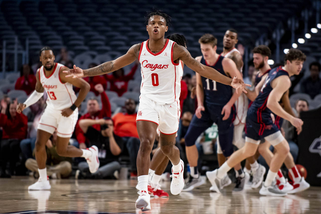 Houston guard Marcus Sasser (0) gestures after assisting on a 3-point shot by guard Jamal Shead dur...