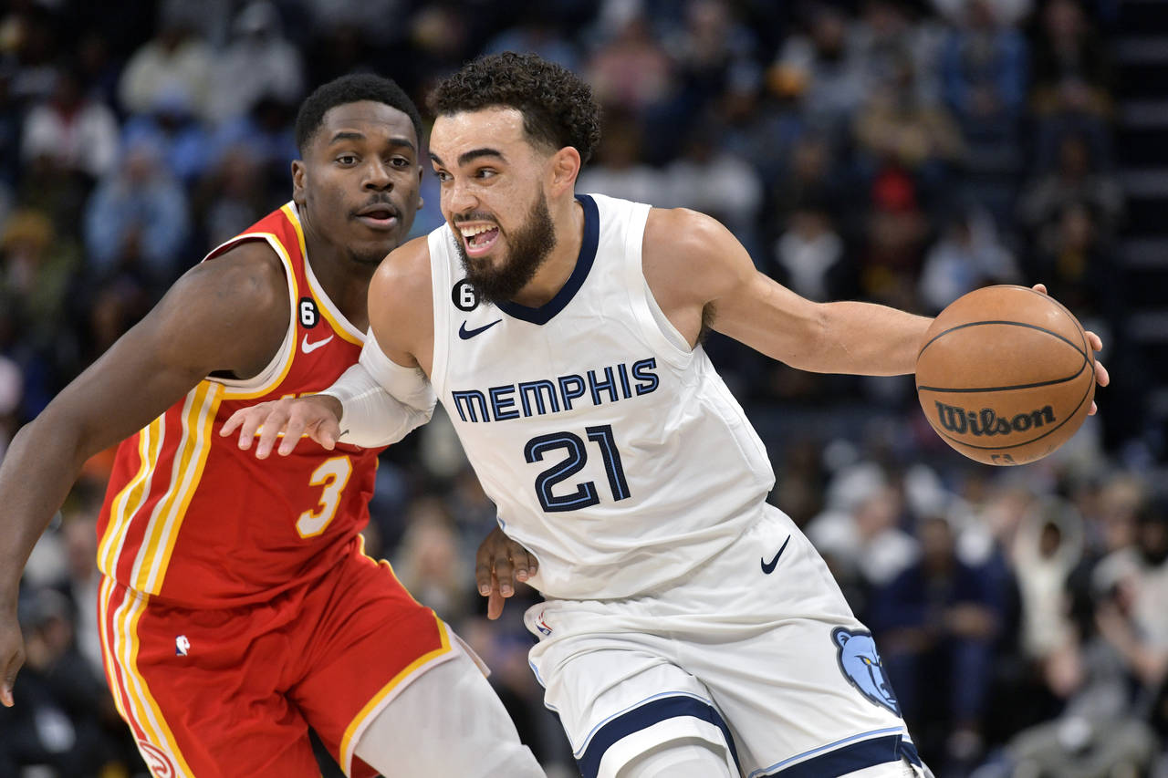Memphis Grizzlies guard Tyus Jones (21) drives against Atlanta Hawks guard Aaron Holiday (3) in the...