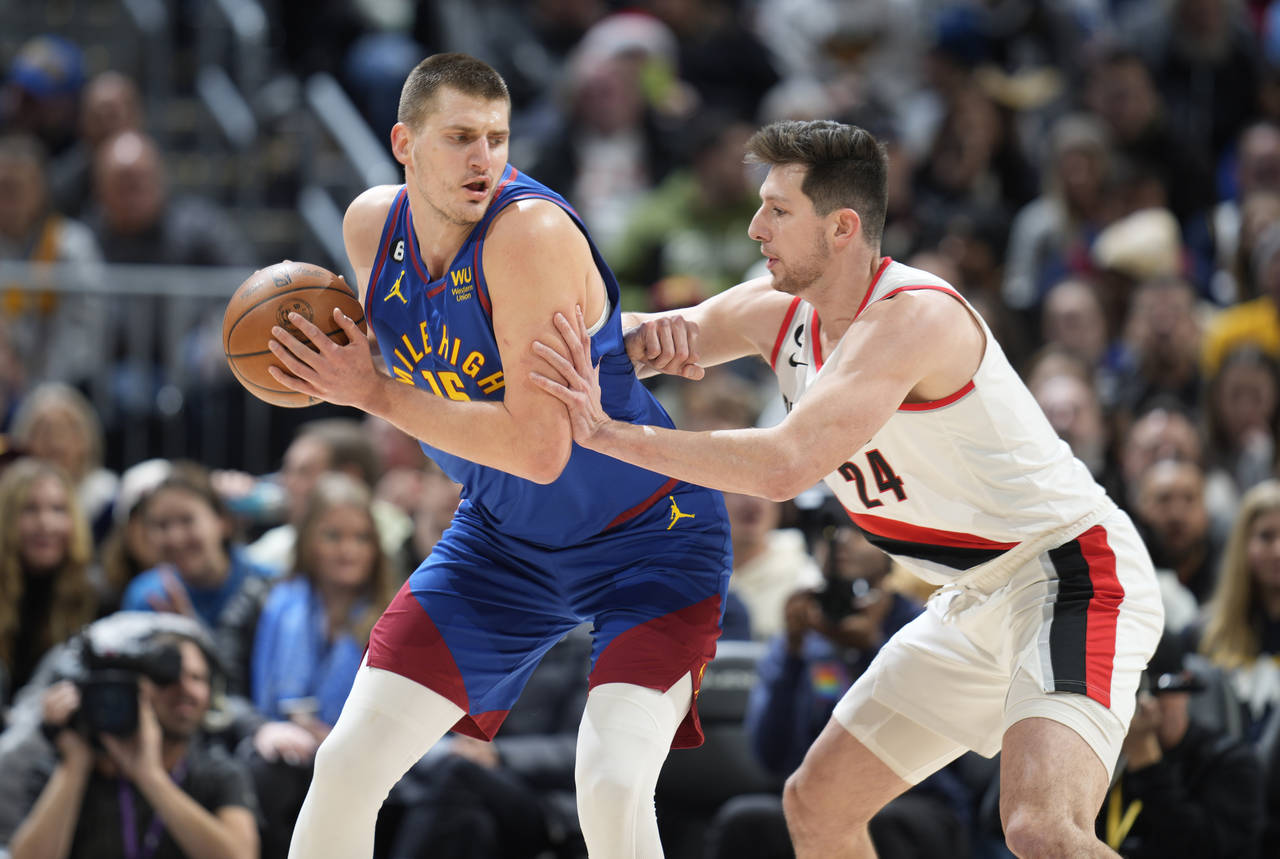 Denver Nuggets center Nikola Jokic, left, looks to drive to the rim as Portland Trail Blazers forwa...