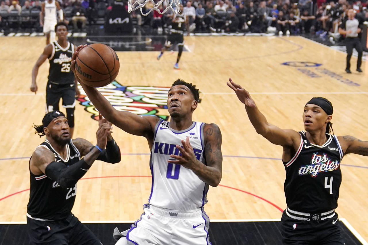 Sacramento Kings guard Malik Monk (0) shoots as Los Angeles Clippers forward Robert Covington (23) ...