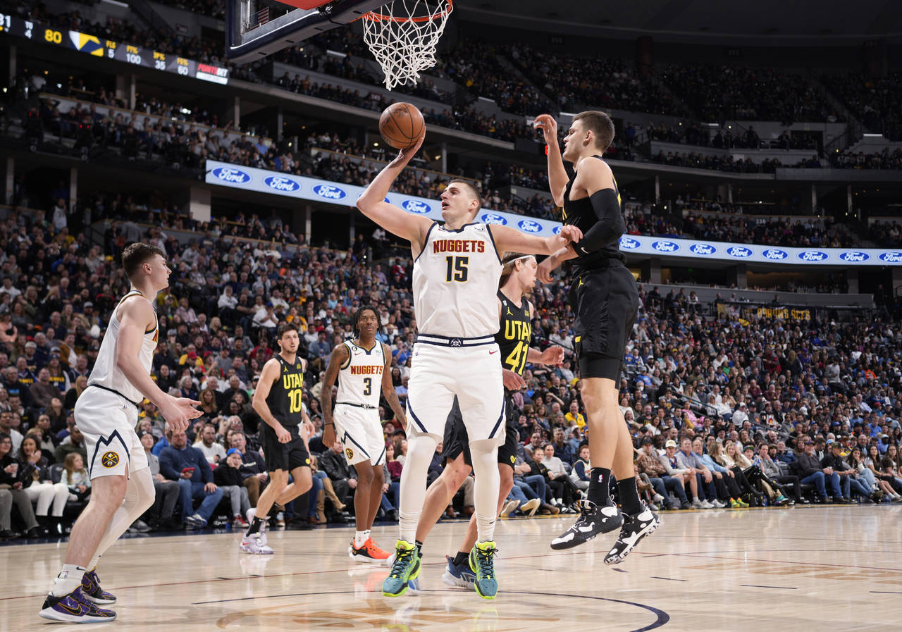 Denver Nuggets center Nikola Jokic (15) pulls down a rebound as Utah Jazz center Walker Kessler, ri...