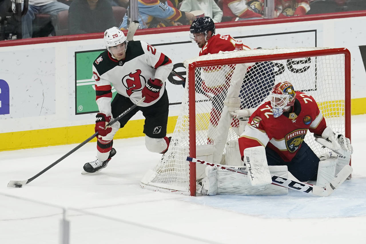 New Jersey Devils center Michael McLeod (20) approaches from behind the net as Florida Panthers goa...