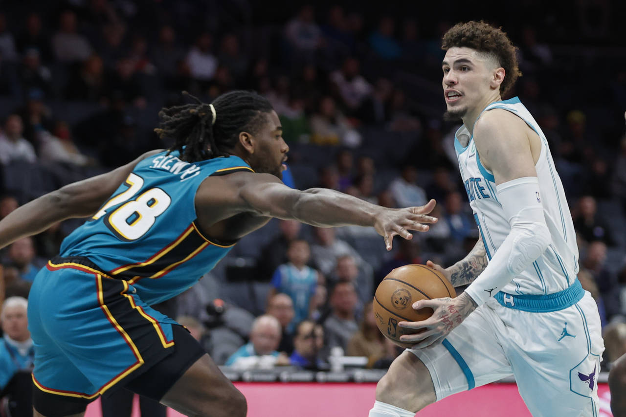 Charlotte Hornets guard LaMelo Ball, right, drives against Detroit Pistons center Isaiah Stewart du...