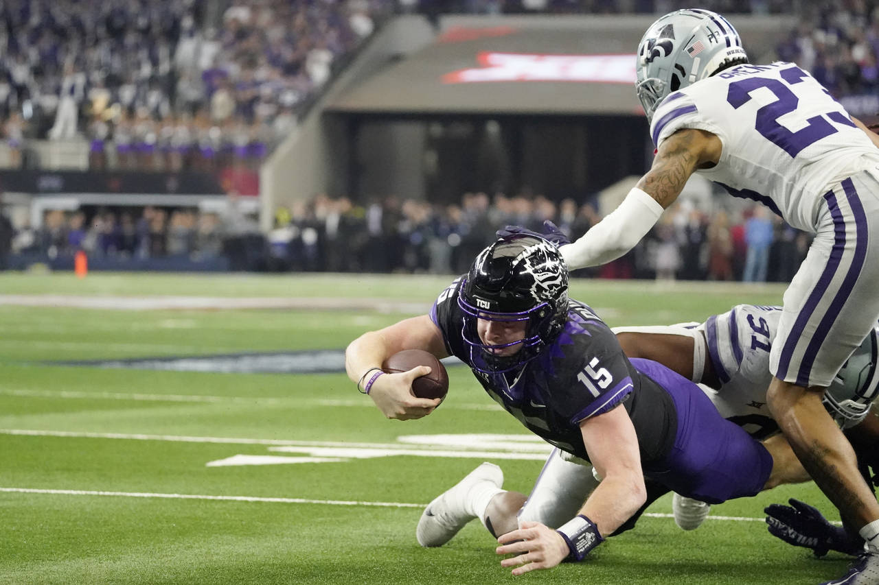 TCU quarterback Max Duggan (15) falls short of a touchdown as Kansas State defensive end Felix Anud...