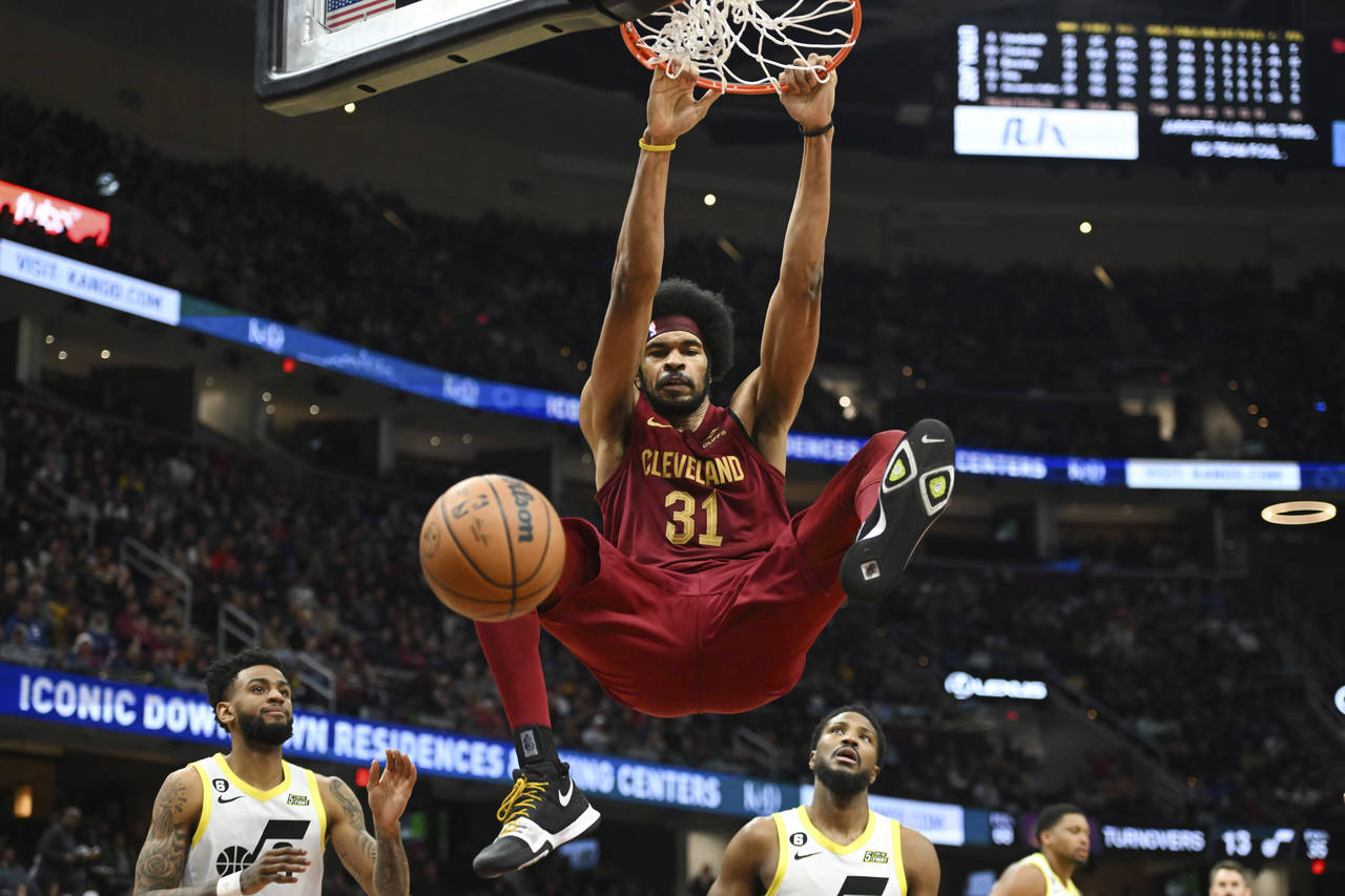 Cleveland Cavaliers center Jarrett Allen hangs from the rim after dunking during the second half of...
